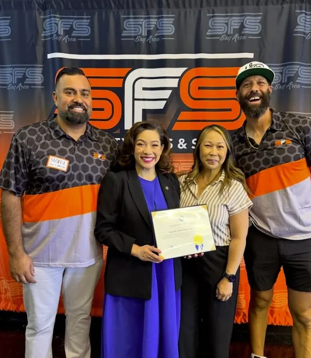 The SFS Bay Area team photographed in front of the SFS Bay Area banner at their San Jose facility